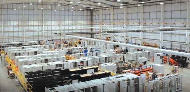Interior of a large industrial building with high ceilings and equipment on the floor